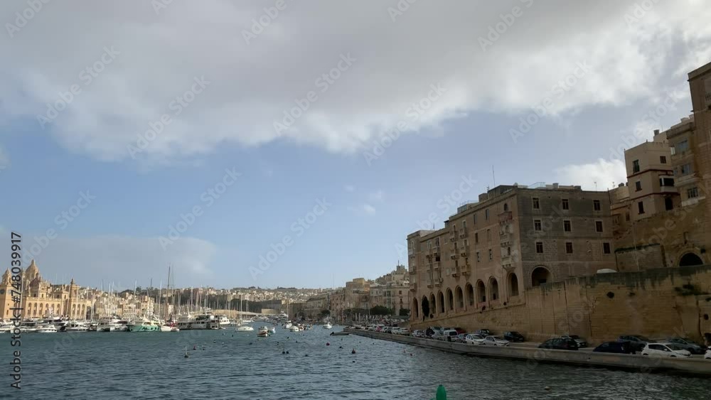 Birgu and Senglea cities skylines. Boats and yachts at Birgu (Vittoriosa) docks, harbour. Three cities waterfront. View from a moving boat. St. Lawrence church in the background. Birgu, Senglea, Malta Birgu and Senglea cities skylines. Boats and yachts at Birgu (Vittoriosa) docks, harbour. Three cities waterfront. View from a moving boat. St. Lawrence church in the background. Birgu, Senglea, Malta