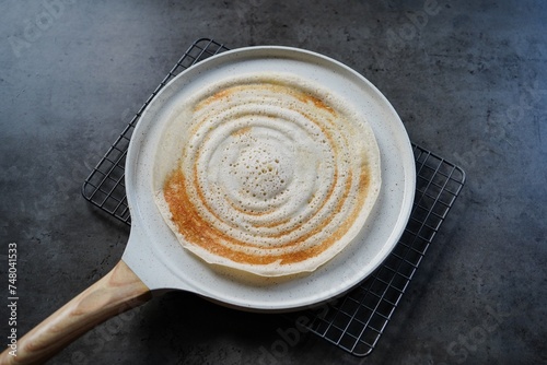 Dosa placed on a non stick ceramic  griddle tawa | Pancake crepe pan photo