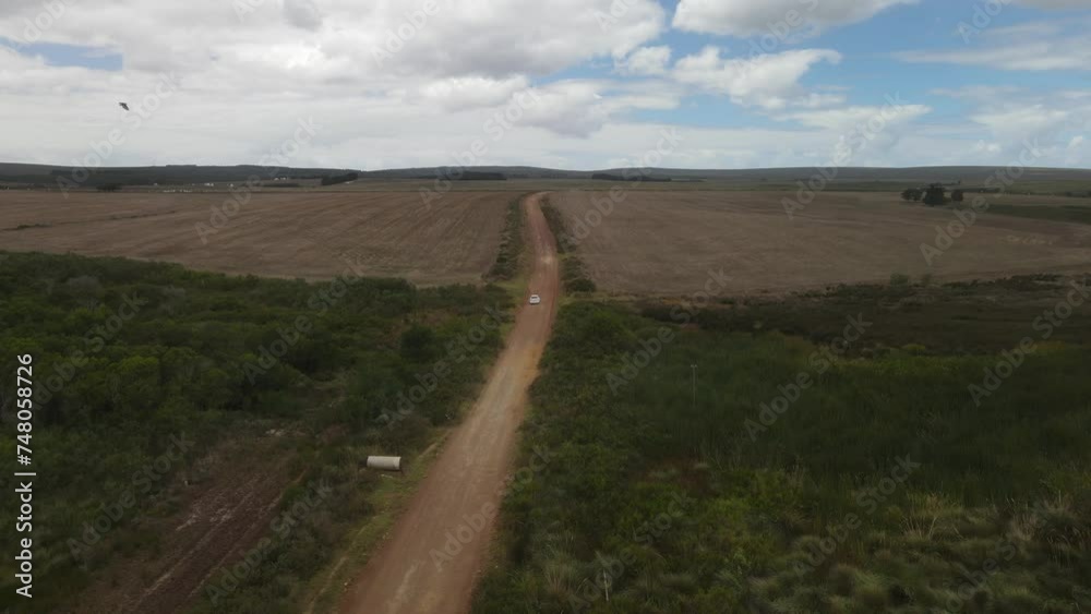 Fly over across South African straight gravel desert road with cloudy sky background Fly over across South African straight gravel desert road with cloudy sky background