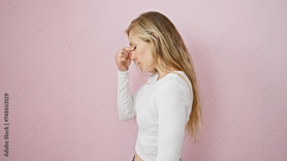 Stressed young blonde woman rubbing tired eyes, standing over pink isolated background, feeling headache and frustration due to fatigue Stressed young blonde woman rubbing tired eyes, standing over pink isolated background, feeling headache and frustration due to fatigue