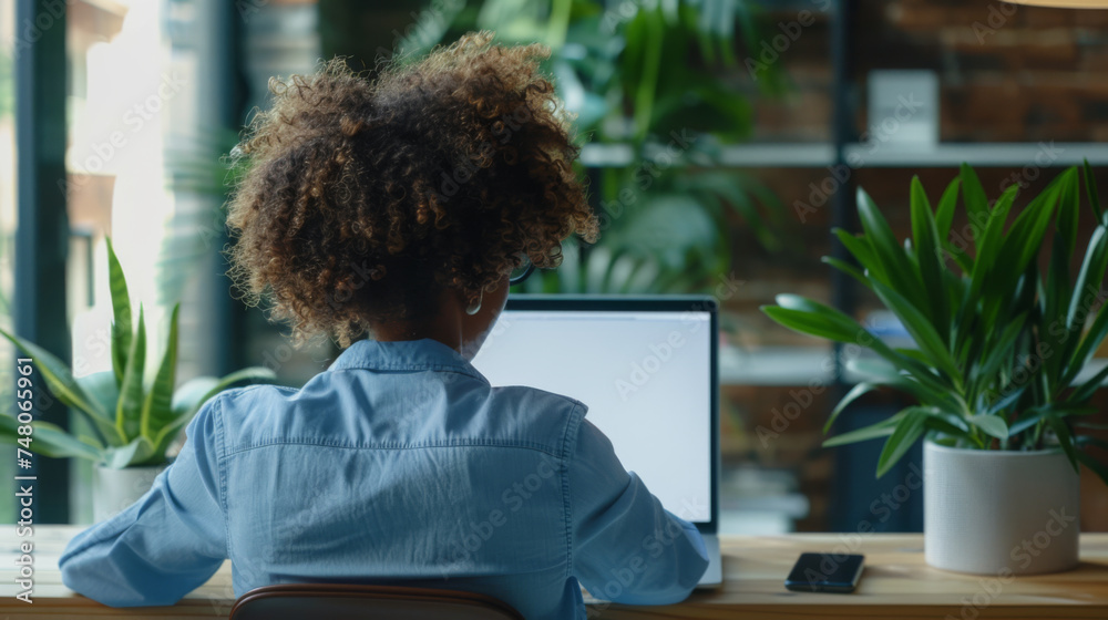 person using a laptop with a blank screen, sitting in a balcony environment surrounded by green plants. person using a laptop with a blank screen, sitting in a balcony environment surrounded by green plants.