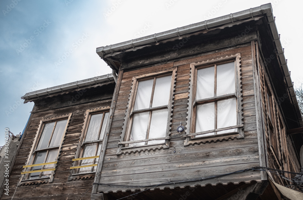 Obraz premium Old weathered wooden house in village. Wooden vintage house in rural. Top of a wooden house and windows.