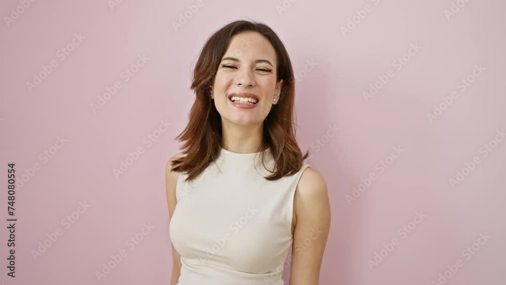 Young beautiful hispanic woman in sleeveless tee, standing with her tongue out, donning a funny face. capturing pure joy, her happiness shines over an isolated pink background. Young beautiful hispanic woman in sleeveless tee, standing with her tongue out, donning a funny face. capturing pure joy, her happiness shines over an isolated pink background.