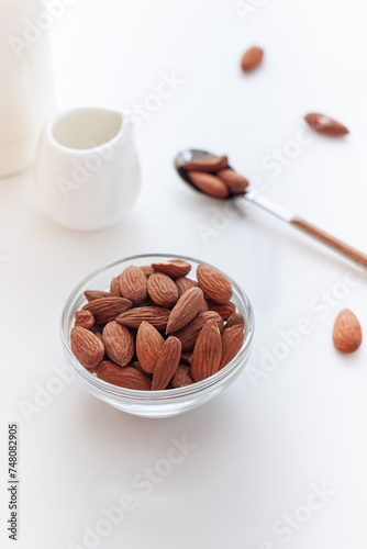 Almond nuts in the glass bowl om the white table close up