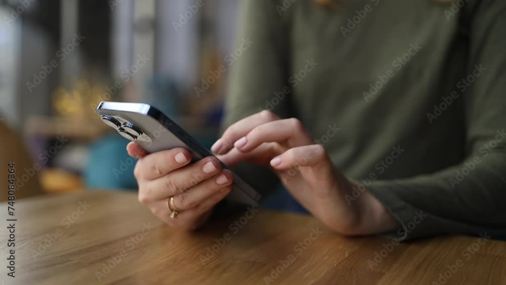 Woman is chilling in a cafe coffee shop and using her smartphone at a table while enjoying her coffee, Close-up High quality FullHD footage Woman is chilling in a cafe coffee shop and using her smartphone at a table while enjoying her coffee, Close-up High quality FullHD footage
