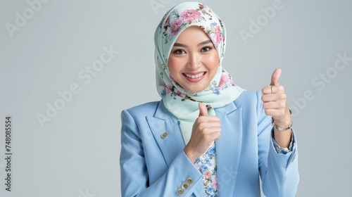 Confidence and positivity with an image of a Malay woman wearing a pastel suit and a flowery hijab, showing thumbs up. Generative AI technology
