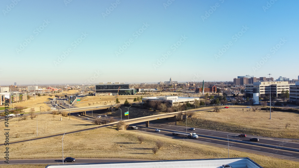 Oklahoma City Centennial Expressway or I-235 Highway loop and overpass aerial view, downtown office buildings, skylines, high rise apartment complex, college campus rooftop parking garage