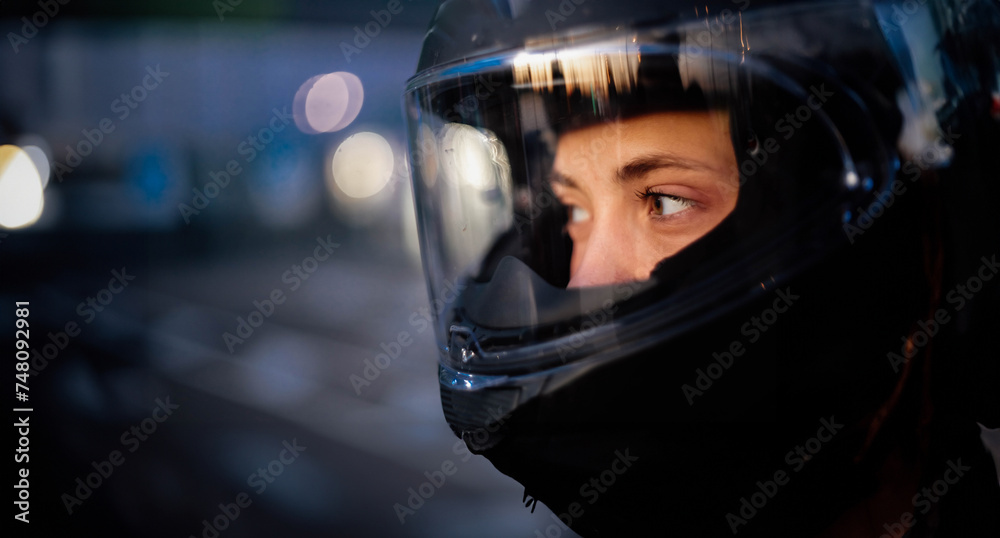 female motorcyclist close-up in a helmet in the evening on a motorcycle in the city. female motorcyclist close-up in a helmet in the evening on a motorcycle in the city.