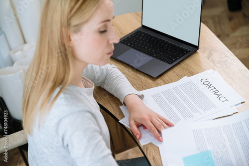 woman working and reading contract or document in office