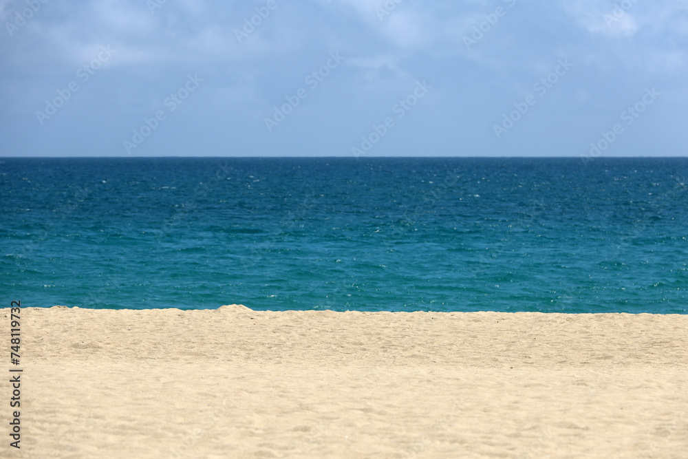 Empty sea beach with white sand, view to blue water and sky. Background for holidays on a paradise nature