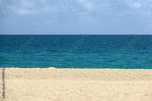 Empty sea beach with white sand, view to blue water and sky. Background for holidays on a paradise nature