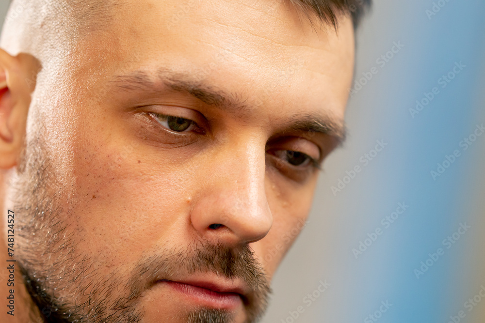 Fototapeta premium close-up portrait of pensive young artist with a beard in an art studio