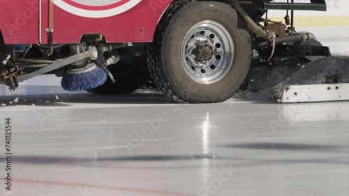 Cleaning the ice of an outdoor ice rink on a sunny day