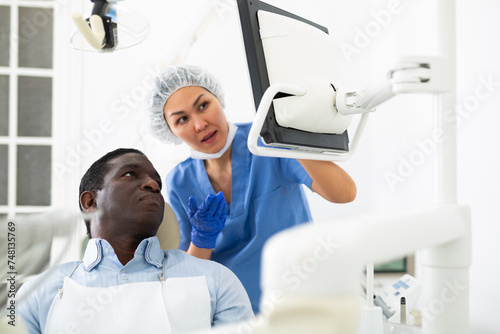 Doctor dentist shows the patient the result of a dental x-ray