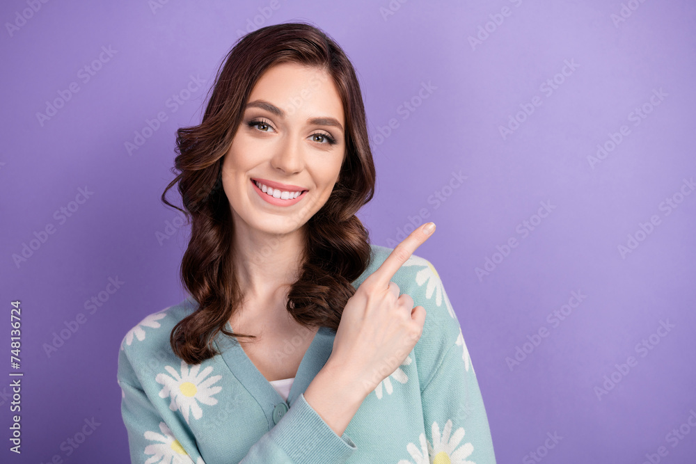 Portrait of young brunette hair happy lady wear cardigan pointing finger announcement billboard in city isolated on violet color background Portrait of young brunette hair happy lady wear cardigan pointing finger announcement billboard in city isolated on violet color background