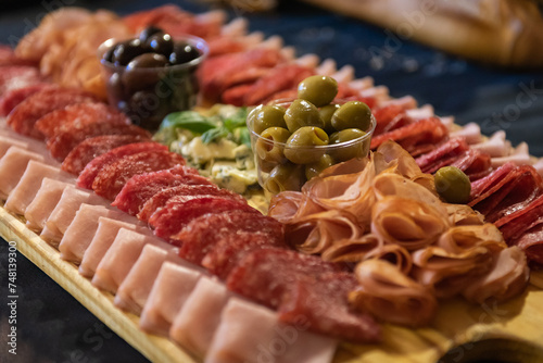 Wooden board with chopped cold cuts. Charcuterie.
