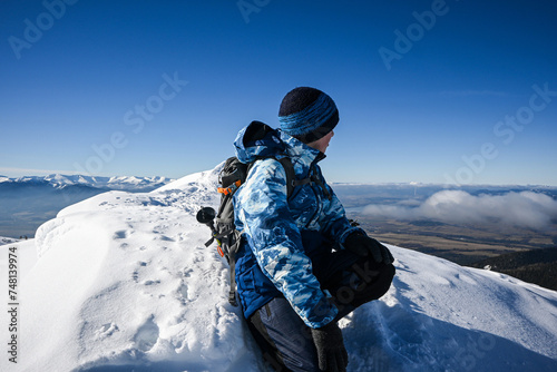 a little boy hiker walks along the snowy ridge of the Western Tatras to Baranec, beautiful view photo