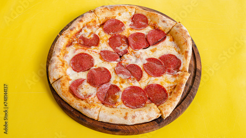 Pizza pepproni top view isolated on yellow background