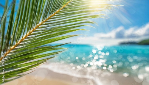 Blur beautiful nature green palm leaf on tropical beach with bokeh sun light wave abstract background. Copy space of summer vacation and travel concept. 