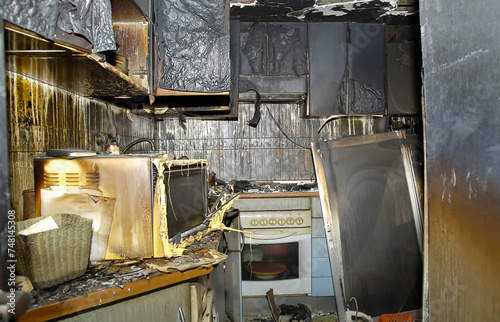Old oven inside the kitchen consumed by flames in a house.