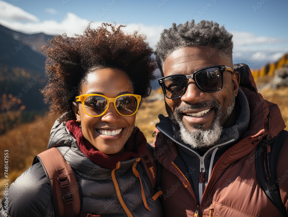 Smiling black couple in outdoor gear hike together in some mountains Smiling black couple in outdoor gear hike together in some mountains