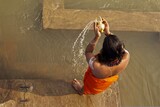 A solitary monk kneels in prayer beside the banks of the Ganges River. With hands clasped and eyes closed in devotion, he immersed himself in the sacred waters and the rhythmic flow of the river.