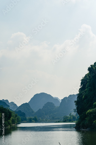 Landscape views of limestone mountains, reflective water and lush greenery of Tran An. A popular spot for tourist to take boat rides while in Northern Vietnam.