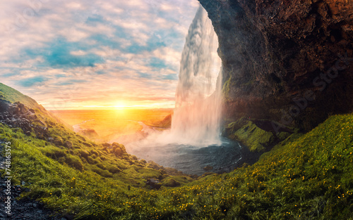 Landscape of sunset shine through Seljalandsfoss waterfall flowing in summer at Iceland