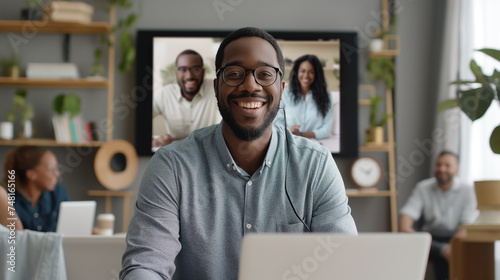 Homem afro-americano sorridente de óculos usando laptop em casa