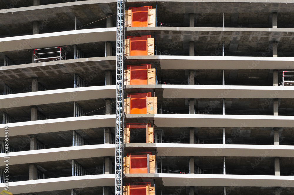 A glimpse of a skyscraper in progress in Tempe, Arizona, showcasing its concrete construction and metallic support beams A glimpse of a skyscraper in progress in Tempe, Arizona, showcasing its concrete construction and metallic support beams