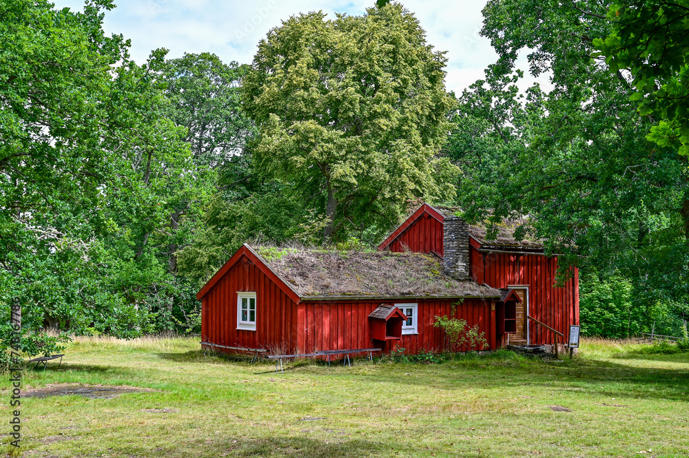 typical, traditional red Swedish house, wooden house with a mossy roof in Hembygdsgard Lunnabacken, a historic homestead near Ugglekull, Urshult, Smaland Sweden typical, traditional red Swedish house, wooden house with a mossy roof in Hembygdsgard Lunnabacken, a historic homestead near Ugglekull, Urshult, Smaland Sweden