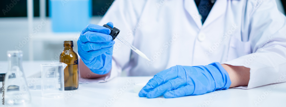 Fototapeta premium Nutritionist or scientist dripping dairy milk to checking the quality and temperature. Concept of nutrition, lactose, protein, bacteria, fat and glucose laboratory. Dairy milk test and research.