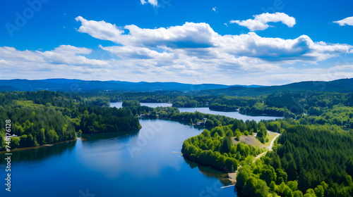 Aerial Drone View of a Serene Lake Encased in Verdant Green Hills Under a Blue Sky