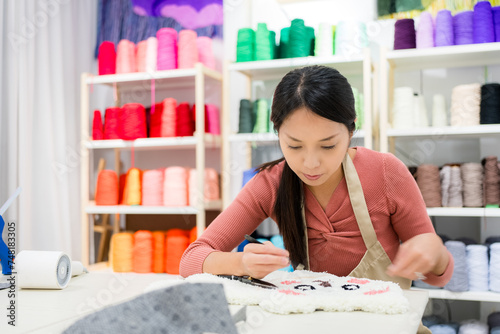 Woman choose the color of thread for making of tufting carpet at studio photo