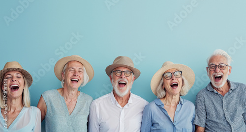 Seniors wearing summer attire laughing heartily against a light blue background, showcasing vitality