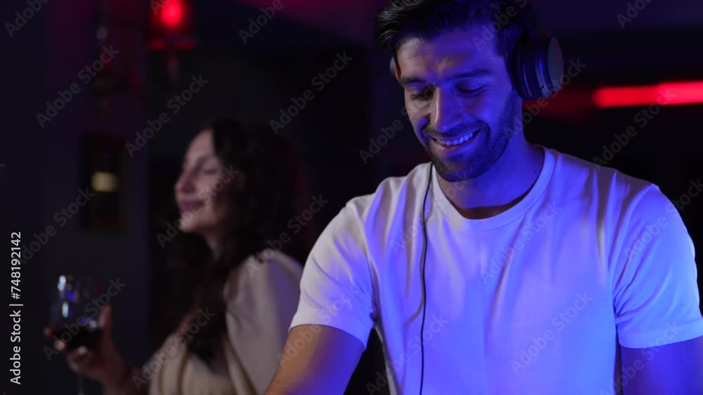 DJ musician man playing and mixing a song with a turntable and headphone. Dance party. excited dj sound device operator with headphones by dancing at club. concept of entertainment in nightlife. DJ musician man playing and mixing a song with a turntable and headphone. Dance party. excited dj sound device operator with headphones by dancing at club. concept of entertainment in nightlife.