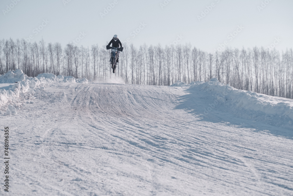Group of motorcycle racers winter race enduro. Winter motocross. Racers ride on ice. Winter sports.