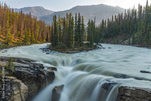 Sunwapta Falls in the stunning Canadian Rockies at sunrise in summertime with beautiful cascading waterfall in popular tourist, landscape area of Canada. 
