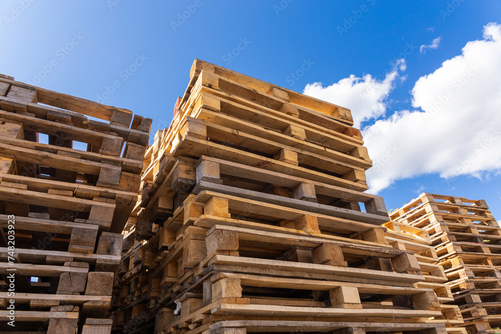 Piles of stacked natural wooden shipping pallets. Piles of stacked natural wooden shipping pallets.