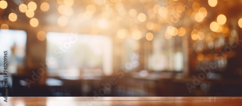 A solid wooden table is featured in the foreground of the image  while the background is blurred with abstract defocused bokeh. It seems to be set in a coffee shop  cafe  or restaurant interior.