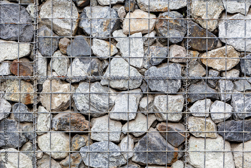 Close up gabion wall caged stones textured background photo