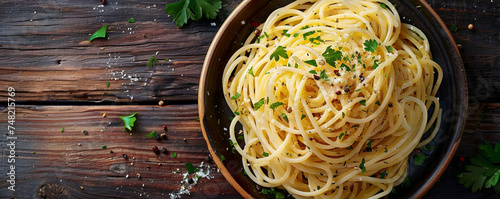 Plate of spaghetti aglio e olio with a sprinkle of parsley. Top view on a rustic wooden surface Top view space to copy photo