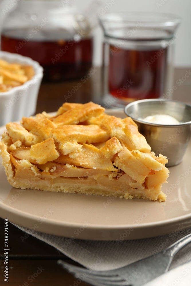 Piece of tasty homemade quince pie with ice cream on table, closeup