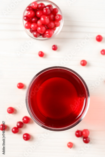 Tasty cranberry juice in glass and fresh berries on white wooden table, flat lay