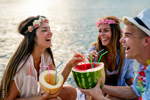 Trendy group of friends drinking cocktails at party. Young people having fun on luxury resort.