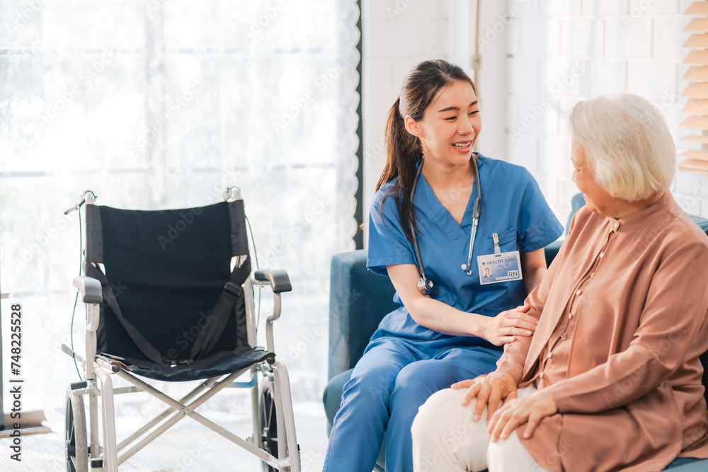 Elderly senior woman, asian woman doctor nursing home to helping take care to retirement patient who sitting on wheelchair, caregiver nurse support to medical health care insurance at home or hospital