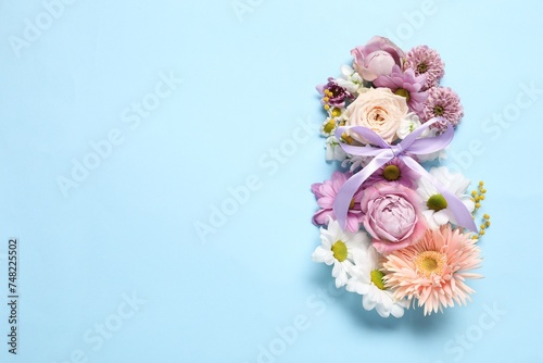 Fototapeta Naklejka Na Ścianę i Meble -  8 March greeting card design made with beautiful flowers on light blue background, top view. Space for text
