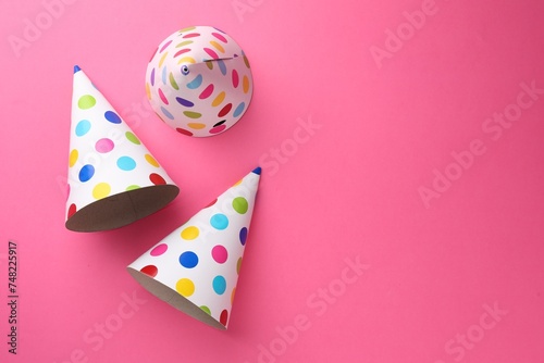 Beautiful party hats on pink background, top view. Space for text