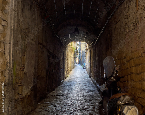 A characteristic Naples alley in the old city, with a scooter parked in the foreground photo