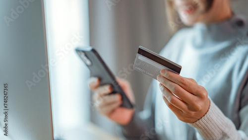 Online payment, Close up - Hands of woman holding a credit card and using smart phone for online shopping